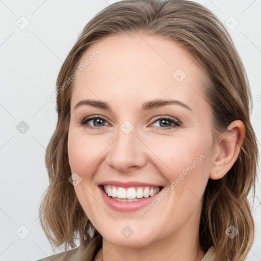 Joyful white young-adult female with long  brown hair and blue eyes