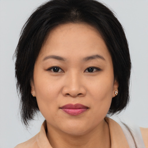 Joyful asian young-adult female with medium  brown hair and brown eyes