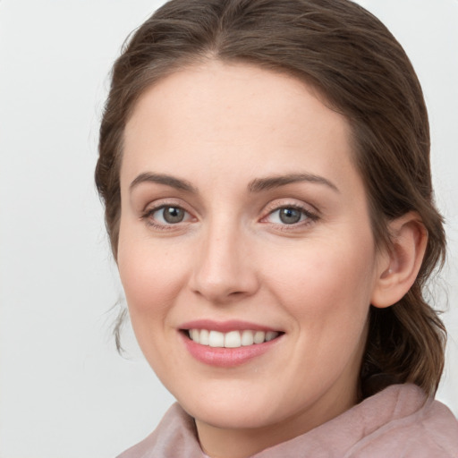 Joyful white young-adult female with medium  brown hair and grey eyes