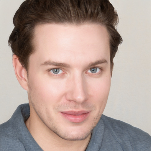 Joyful white young-adult male with short  brown hair and blue eyes