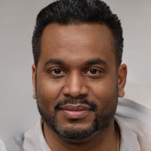 Joyful black young-adult male with short  black hair and brown eyes