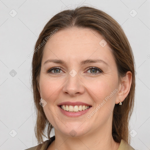 Joyful white adult female with medium  brown hair and grey eyes