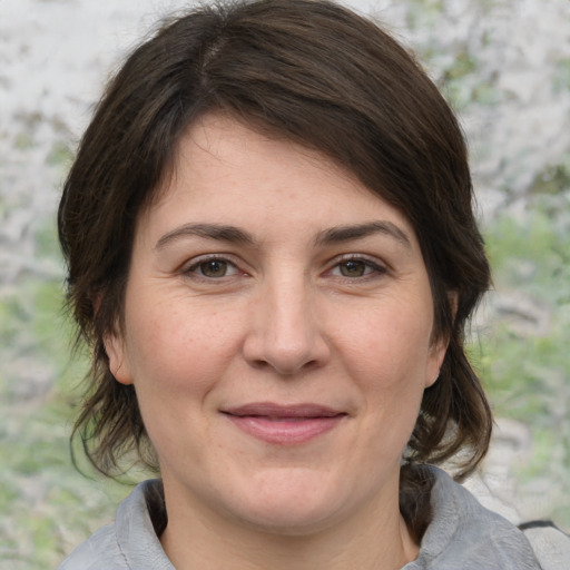 Joyful white adult female with medium  brown hair and grey eyes