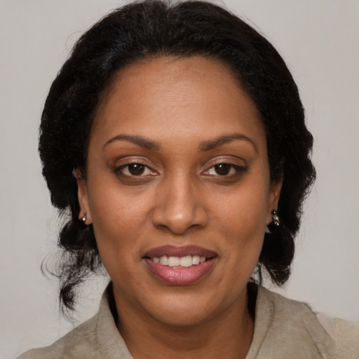 Joyful black adult female with medium  brown hair and brown eyes