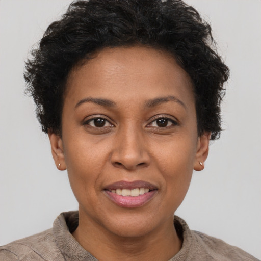 Joyful black young-adult female with short  brown hair and brown eyes