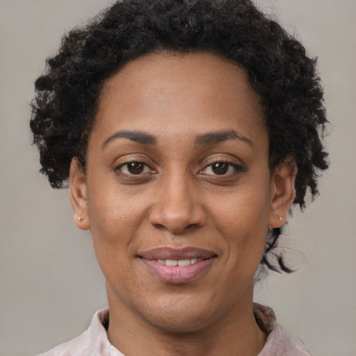 Joyful black adult female with short  brown hair and brown eyes