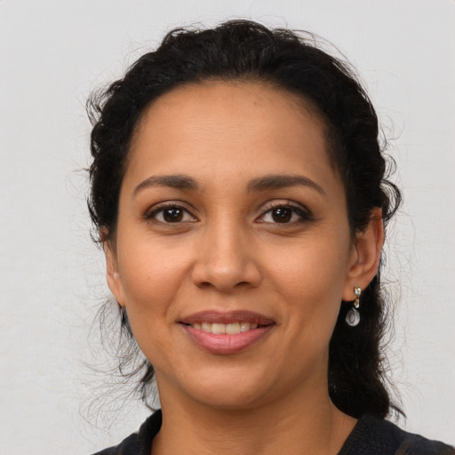 Joyful latino young-adult female with medium  brown hair and brown eyes