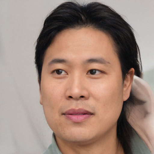 Joyful asian adult male with short  brown hair and brown eyes