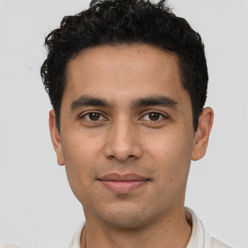 Joyful latino young-adult male with short  black hair and brown eyes