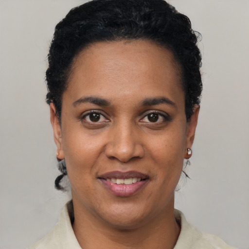 Joyful black young-adult female with short  black hair and brown eyes