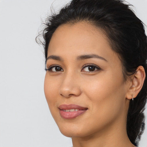 Joyful latino young-adult female with long  brown hair and brown eyes