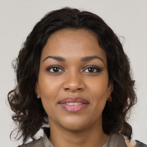 Joyful black young-adult female with medium  brown hair and brown eyes