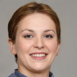 Joyful white young-adult female with medium  brown hair and grey eyes