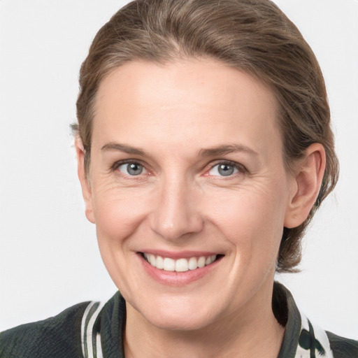 Joyful white adult female with medium  brown hair and grey eyes