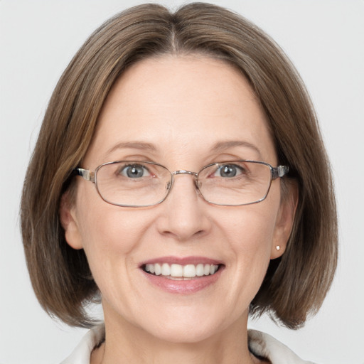 Joyful white adult female with medium  brown hair and grey eyes