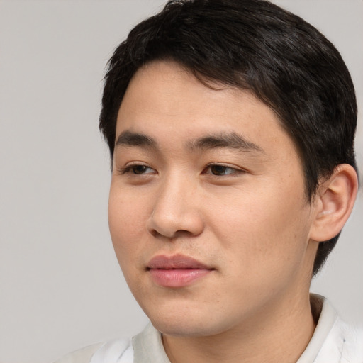 Joyful asian young-adult male with short  black hair and brown eyes