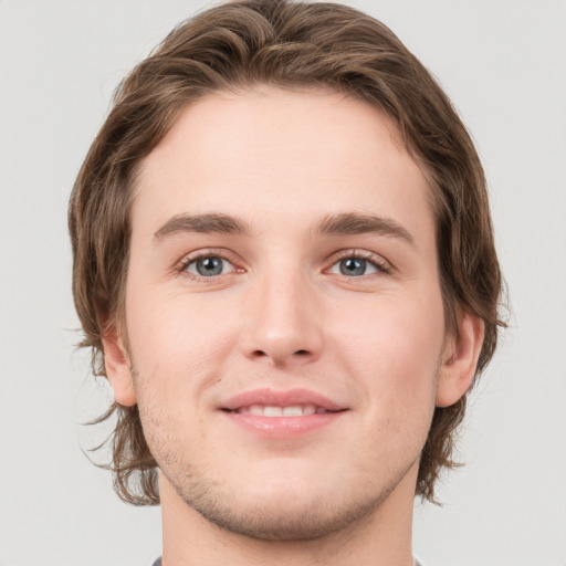 Joyful white young-adult male with medium  brown hair and grey eyes