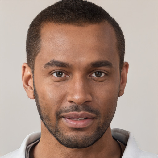 Joyful black young-adult male with short  brown hair and brown eyes