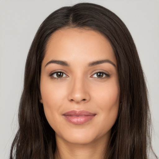 Joyful latino young-adult female with long  brown hair and brown eyes