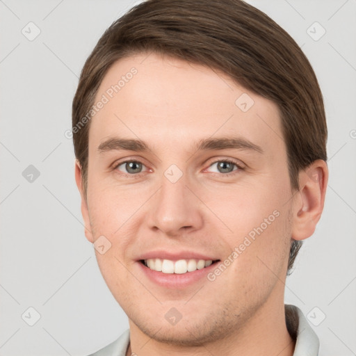 Joyful white young-adult male with short  brown hair and grey eyes