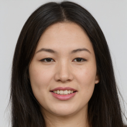 Joyful asian young-adult female with long  brown hair and brown eyes