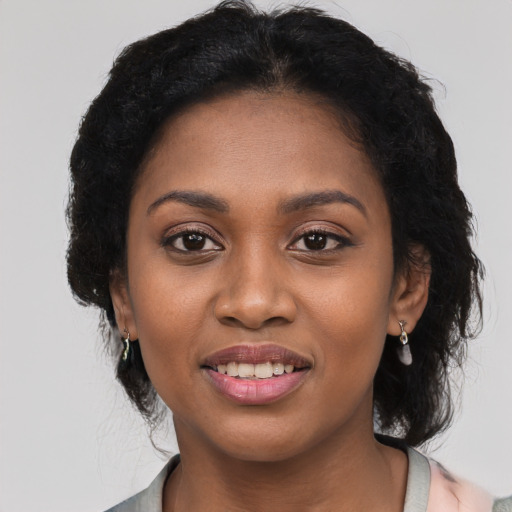 Joyful black young-adult female with long  black hair and brown eyes