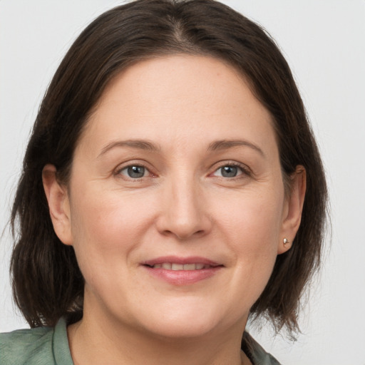 Joyful white adult female with medium  brown hair and grey eyes