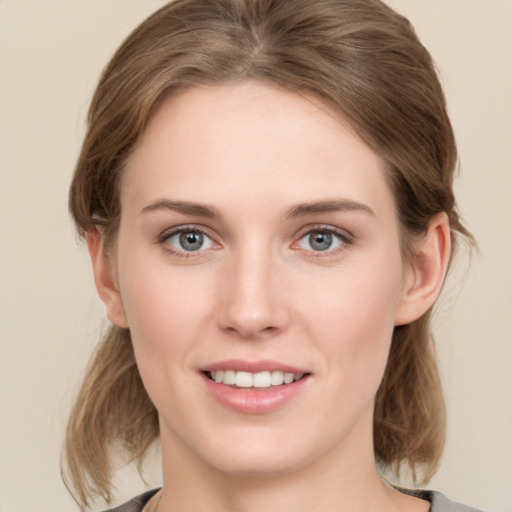 Joyful white young-adult female with medium  brown hair and grey eyes