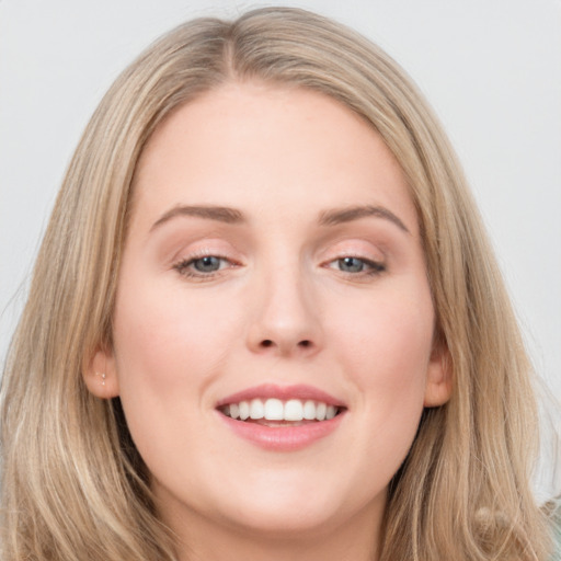 Joyful white young-adult female with long  brown hair and blue eyes