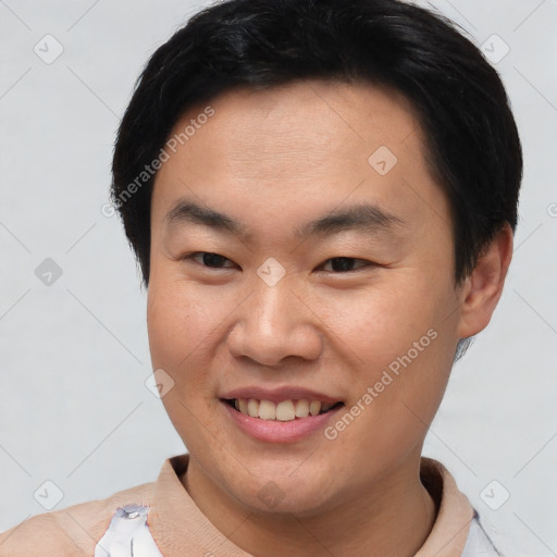 Joyful asian young-adult male with short  brown hair and brown eyes