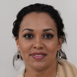 Joyful black adult female with medium  brown hair and brown eyes