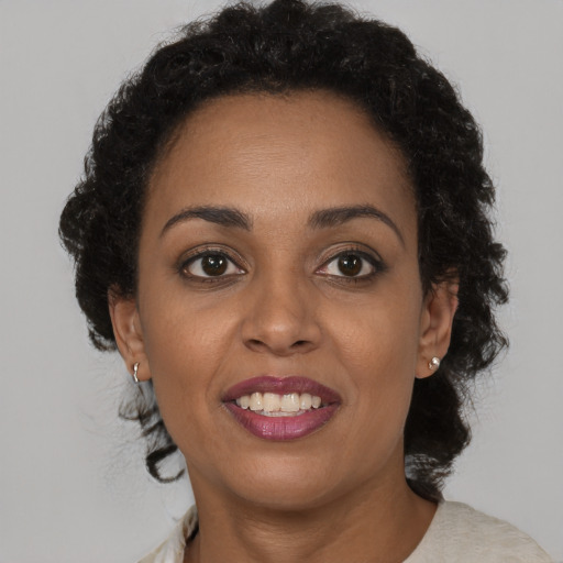 Joyful black adult female with short  brown hair and brown eyes