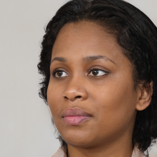 Joyful black young-adult female with medium  brown hair and brown eyes