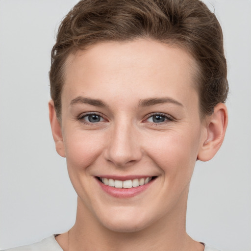 Joyful white young-adult female with short  brown hair and grey eyes