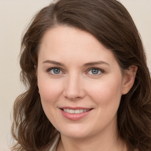 Joyful white young-adult female with long  brown hair and grey eyes