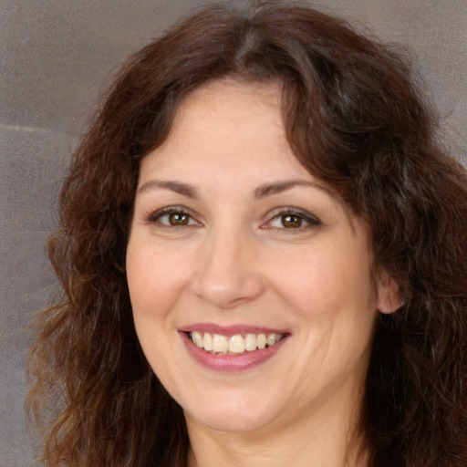 Joyful white adult female with long  brown hair and brown eyes