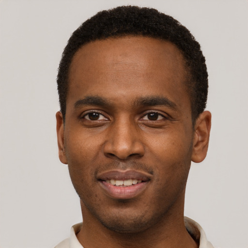 Joyful black young-adult male with short  brown hair and brown eyes