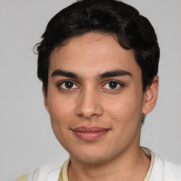 Joyful latino young-adult male with short  black hair and brown eyes