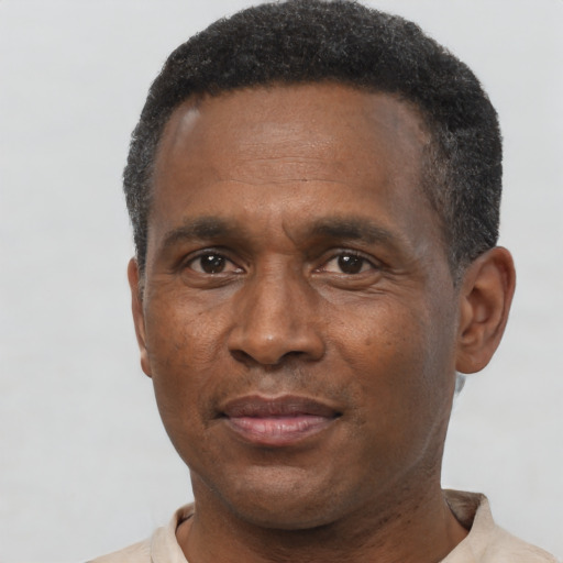 Joyful black adult male with short  black hair and brown eyes