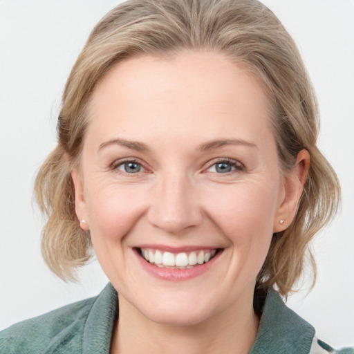 Joyful white young-adult female with medium  brown hair and blue eyes