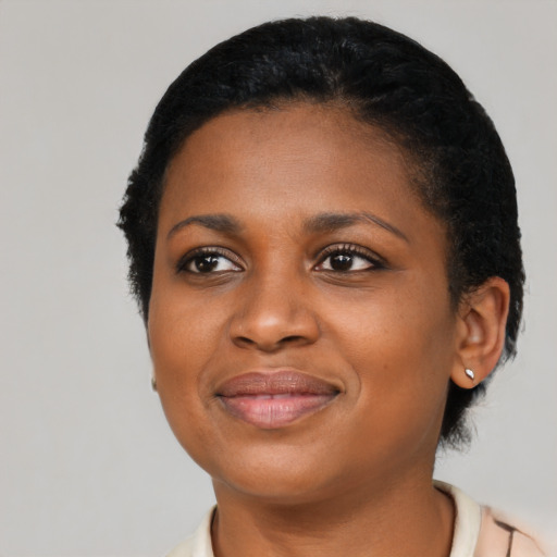 Joyful black young-adult female with short  black hair and brown eyes