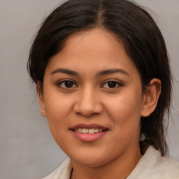 Joyful latino young-adult female with medium  brown hair and brown eyes