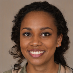 Joyful black young-adult female with long  brown hair and brown eyes