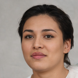 Joyful latino young-adult female with medium  brown hair and brown eyes