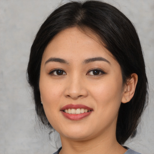 Joyful asian young-adult female with medium  black hair and brown eyes