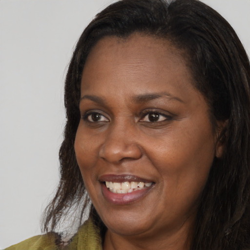 Joyful black adult female with long  brown hair and brown eyes