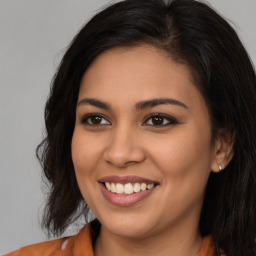 Joyful latino young-adult female with long  brown hair and brown eyes