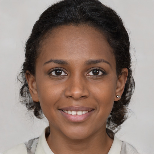 Joyful black young-adult female with medium  brown hair and brown eyes