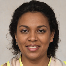 Joyful latino adult female with medium  brown hair and brown eyes