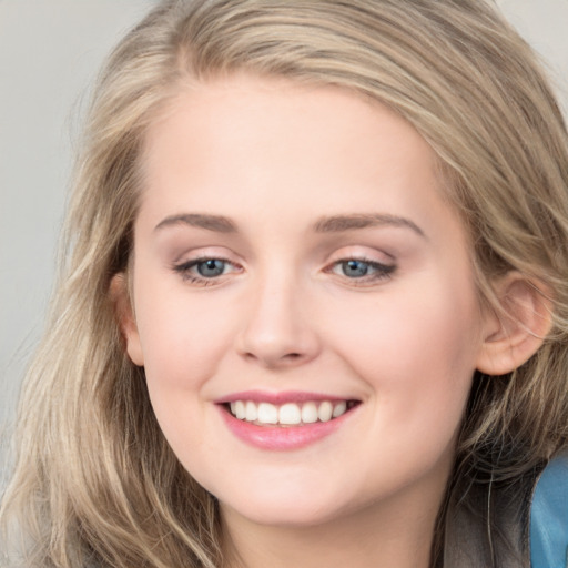 Joyful white young-adult female with long  brown hair and blue eyes